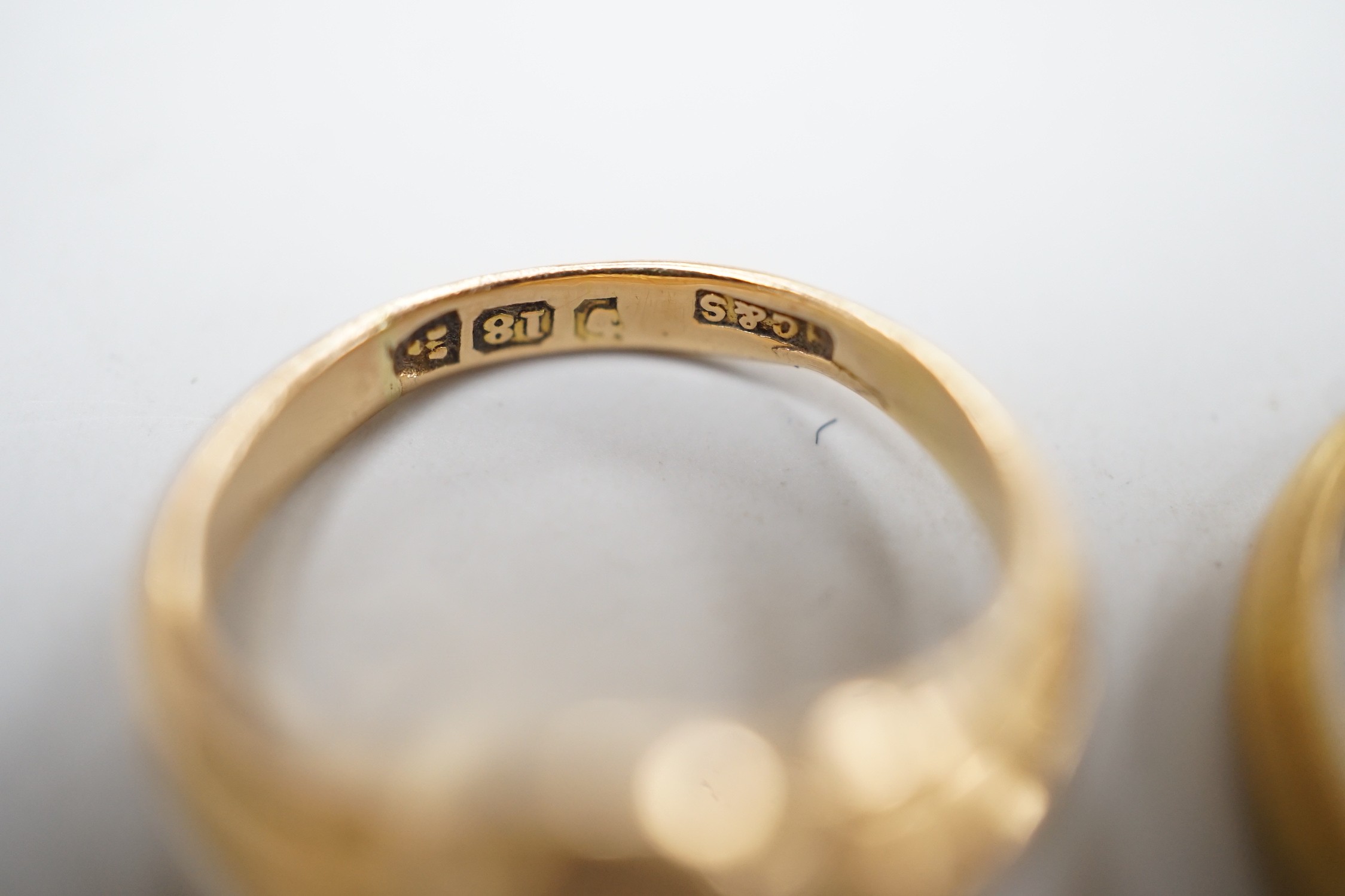 An early 20th century small 18ct gold signet ring, engraved with armorial, size G/H and a modern 18ct gold band, size I, with engraved inscription, 7.6 grams.